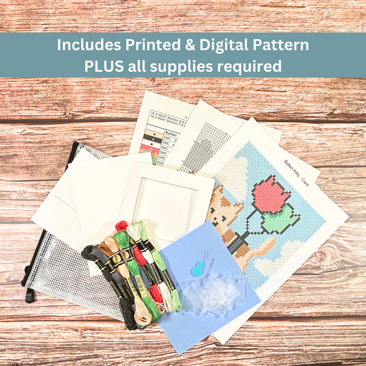 Complete cross-stitch kit including Aida cloth, embroidery floss, pattern sheets, and greeting card materials.