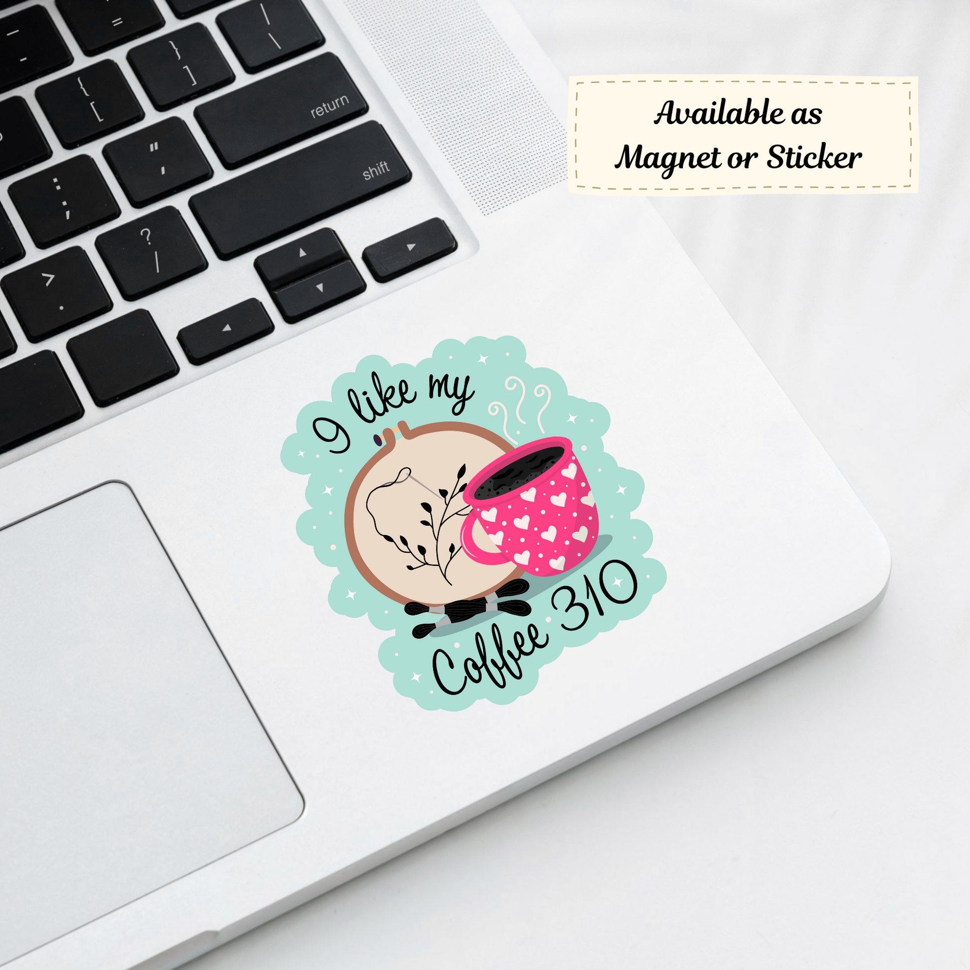 ‘I Like My Coffee 310’ sticker on silver laptop corner, showcasing cross stitch themed design