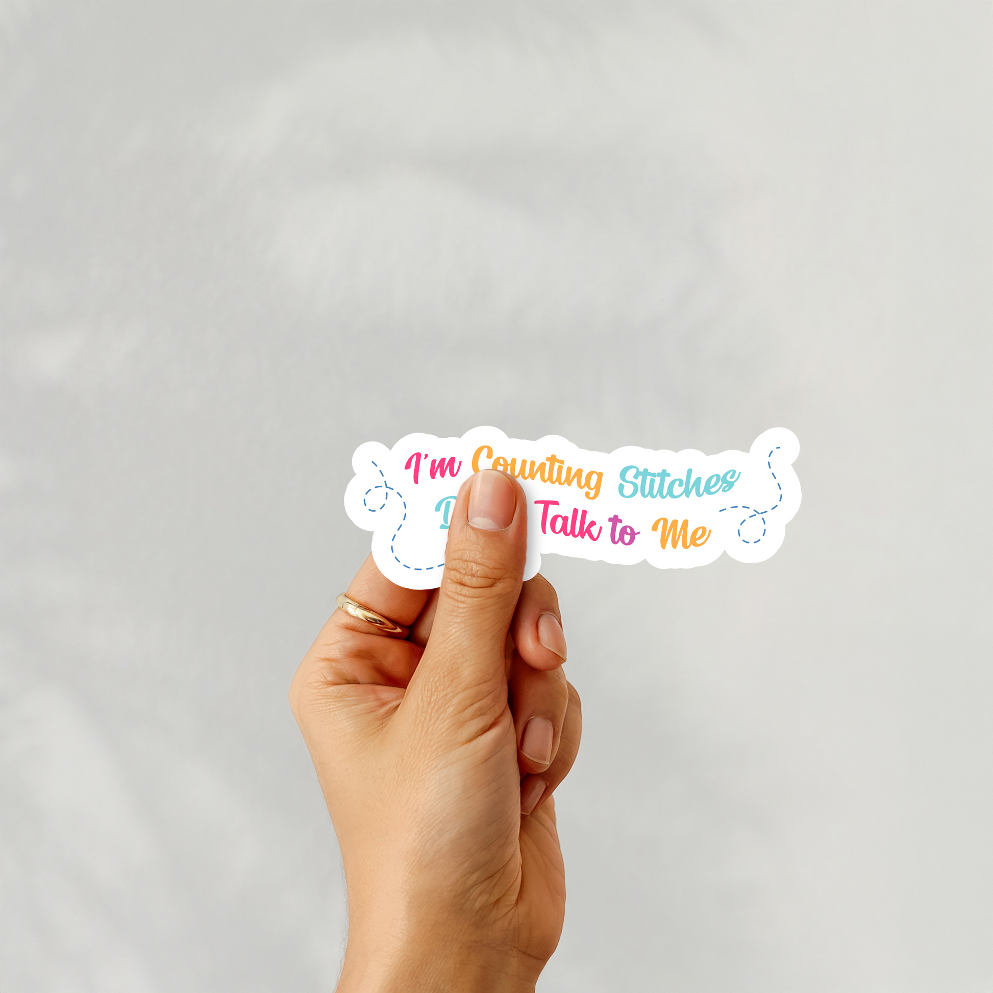 Handheld sticker of “I’m Counting Stitches Don’t Talk to Me” cross-stitch design