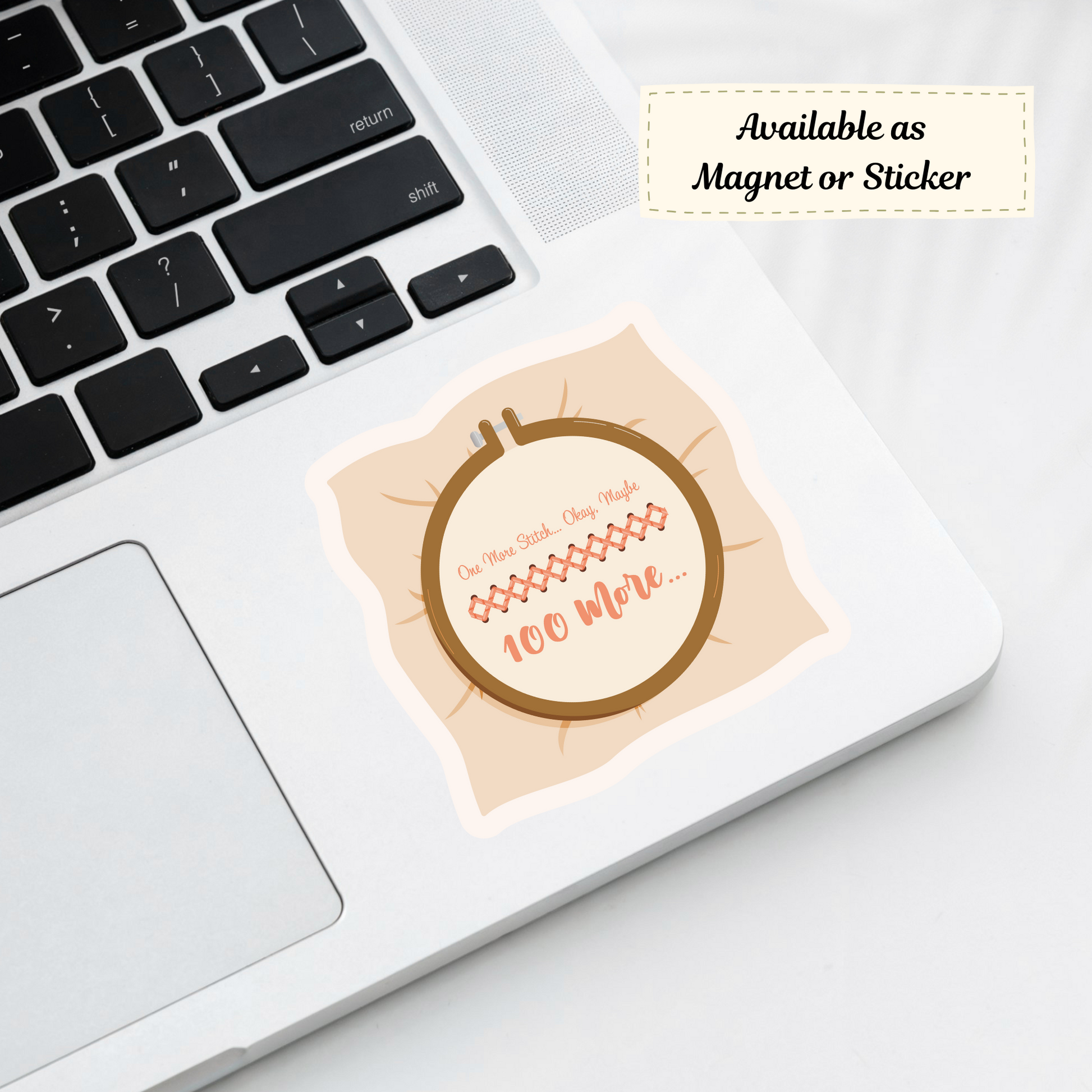 Cross-stitch sticker applied to a laptop among embroidery supplies.