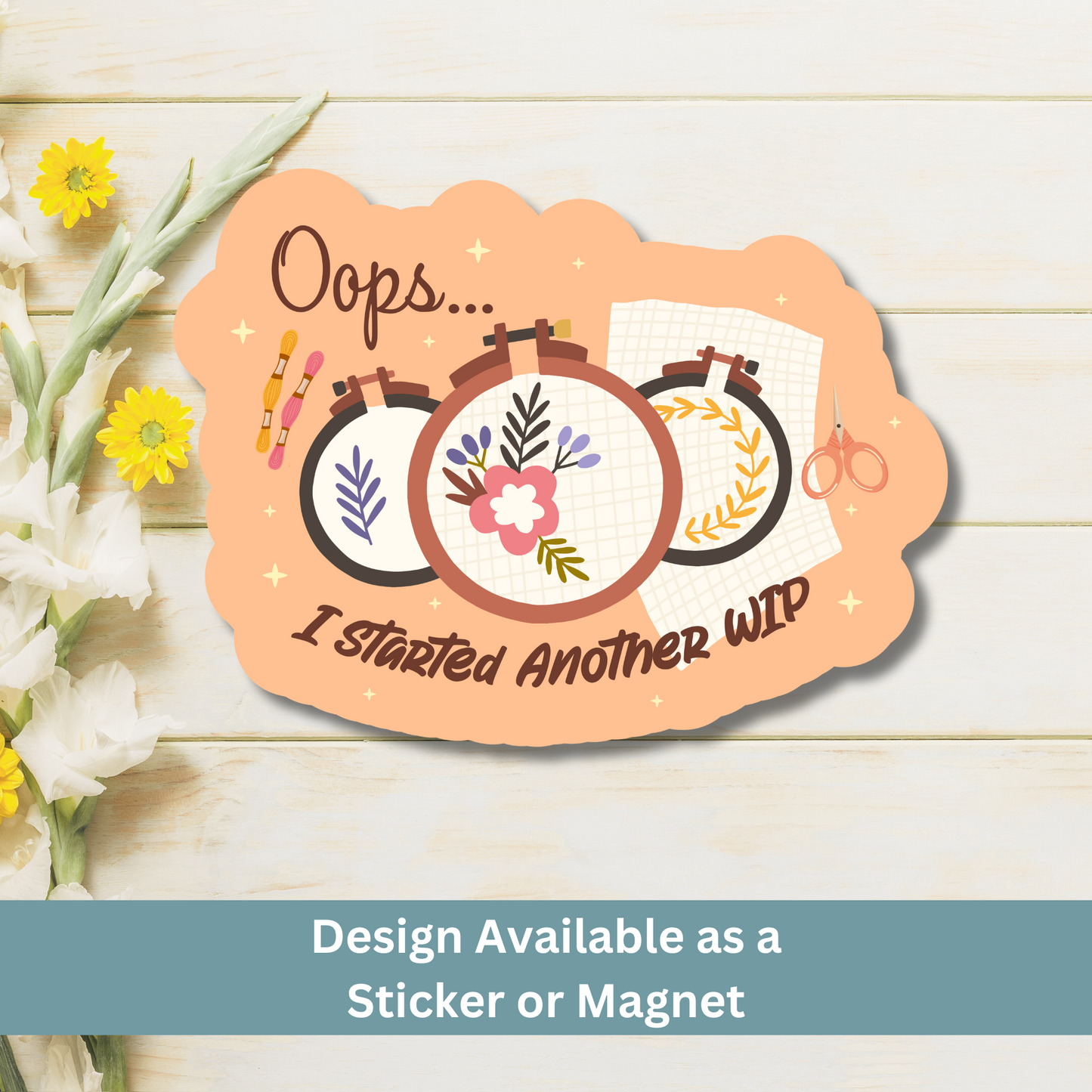 ‘Oops... I Started Another WIP’ magnet flat lay on light wood background with floral hoop art