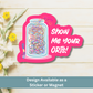 ‘Show Me Your ORTs!’ magnet flat lay on light wood featuring colorful thread jar illustration